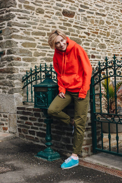 Smiling young woman leaning at fence and looking away on cozy street, mont saint michel, france — Stock Image Smiling Young Woman Leaning Fence Looking Away Cozy Street Mont Royalty Free Stock Photos