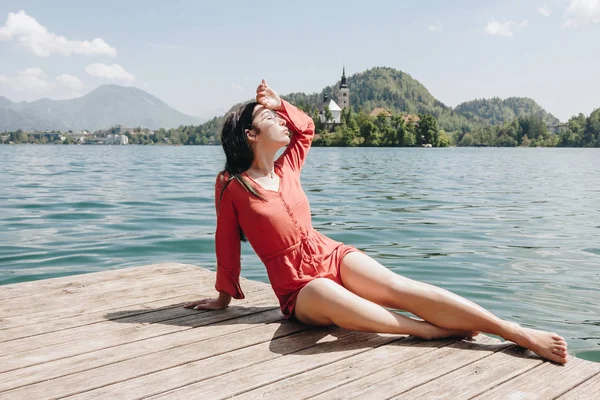 Beautiful young woman resting on wooden pier at scenic mountain lake, bled, slovenia — Stock Image Beautiful Young Woman Resting Wooden Pier Scenic Mountain Lake Bled Royalty Free Stock Images