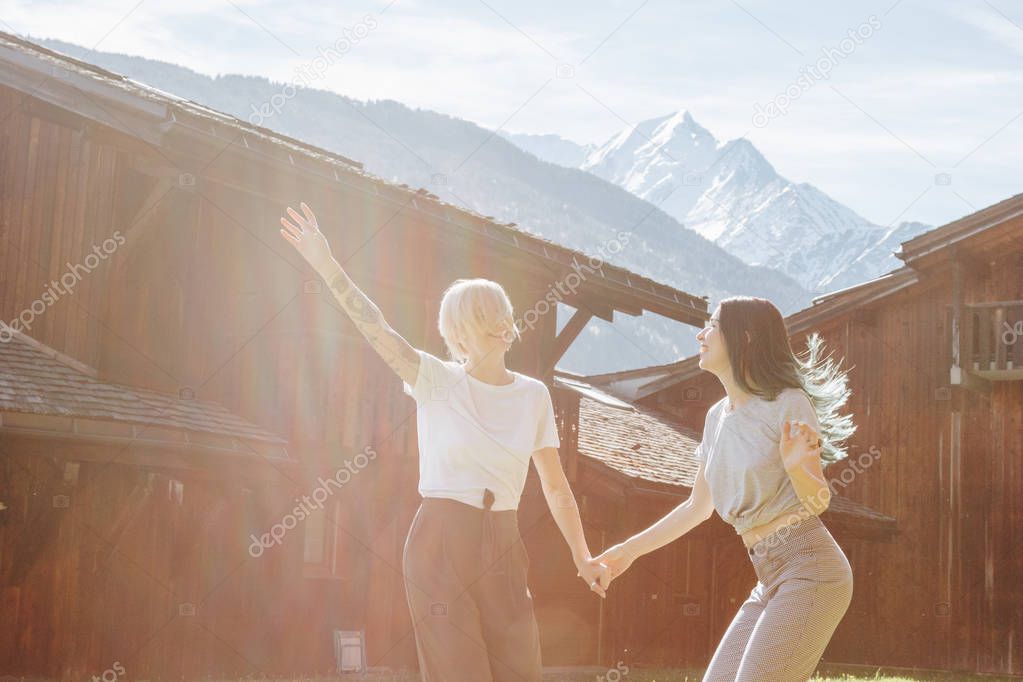 beautiful happy girls holding hands and having fun in mountain village, mont blanc, alps