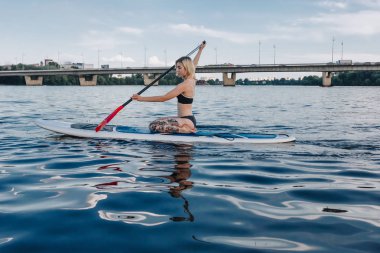 dövmeli kız nehrinde kürek gemide sörf