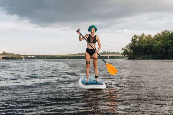 Attractive Tattooed Girl Blue Hair Paddle Boarding River — Free Stock Photo