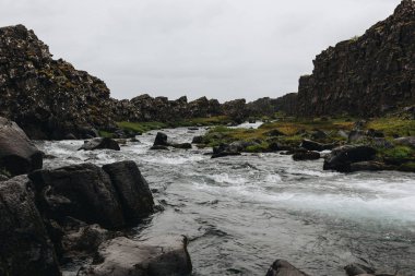 highlands İzlanda Thingvellir Ulusal parkında bulutlu gökyüzü altında akan güzel dağ Nehri