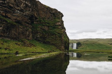 güzel şelale Skogafoss Highlands İzlanda'daki bulutlu gökyüzü altında doğal görünümünü 