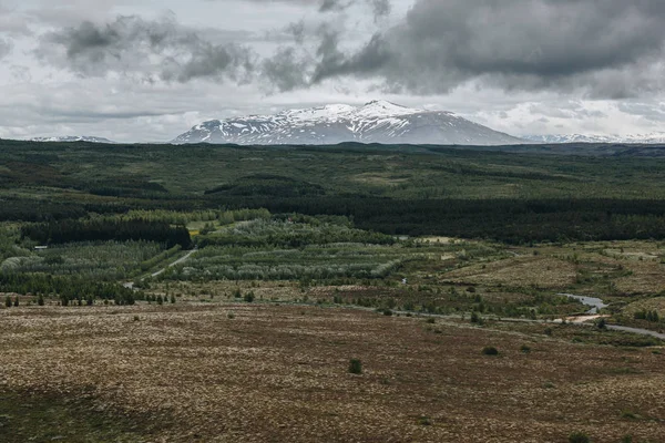 冰岛多云天空下积雪覆盖的山脉景观 — 免费的图库照片