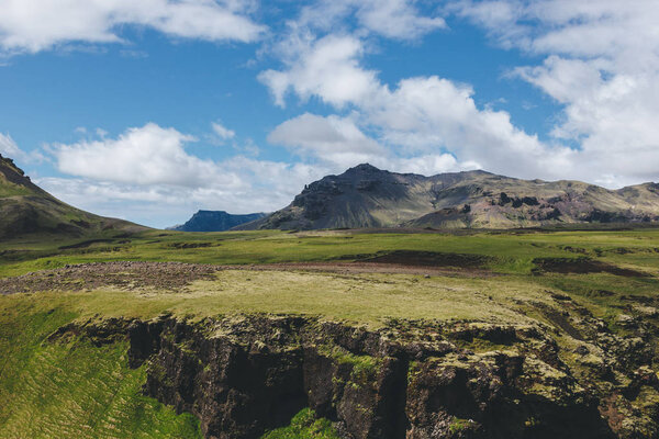 scenic view of landscape with mountains range under blue cloudy sky in Iceland 