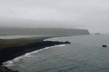 kayalık uçurum ve Dyrholaey promontory Vik, İzlanda, bulutlu gökyüzü altında siyah kum plaj havadan görünümü