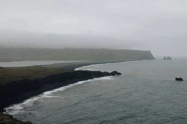 在冰岛 Vik Dyrholaey 在多云的天空下 岩石悬崖和黑色沙滩的鸟瞰图 — 图库照片