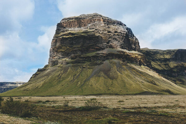 scenic view of beautiful mountain under cloudy blue sky in Iceland 