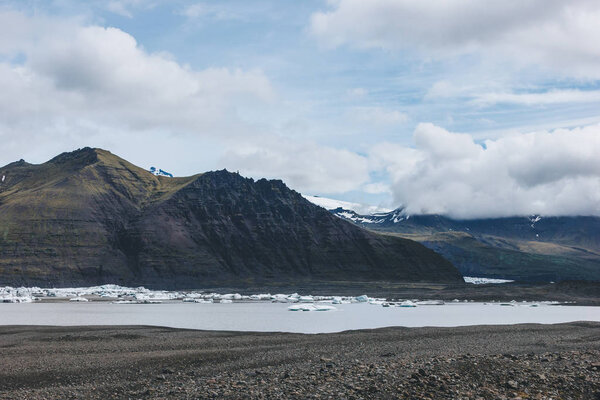 beautiful mountains and lake under cloudy sky in Skaftafell national park in Iceland 