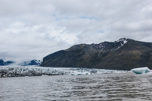 landscape with glacier Skaftafellsjkull and snowy mountains against cloudy sky in Skaftafell National Park in Iceland 