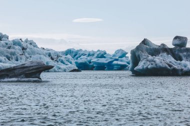 Jokulsarlon, İzlanda gölde mavi gökyüzü altında yüzen mavi buz parçaları