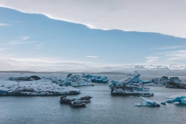 scenic shot of glacier ice pieces floating in lake in Jokulsarlon, Iceland clipart