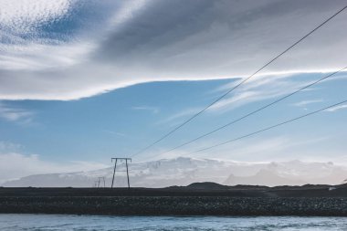 güzel İzlandaca sky yukarıda yüksek gerilim kabloları ve mavi nehir, Jokulsarlon, İzlanda
