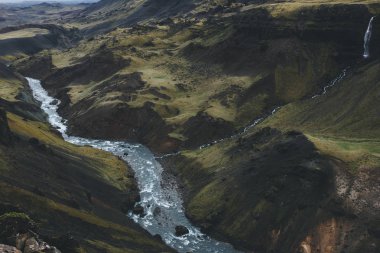 aerial view of curvy river streaming in green hills in Iceland clipart