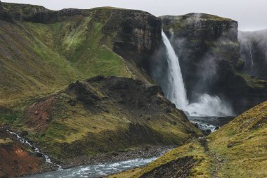 Haifoss Şelalesi ve yeşil tepeler sisli gün ile İzlanda manzara