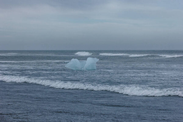 blue glacier ice piece floating in ocean water, Iceland