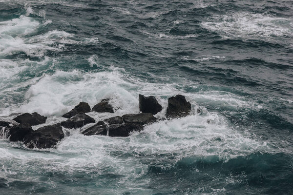 dramatic shot of ocean waves crashing on rocks for background