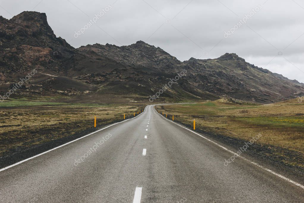 Empty asphalt road in Iceland with beautiful mountains on background