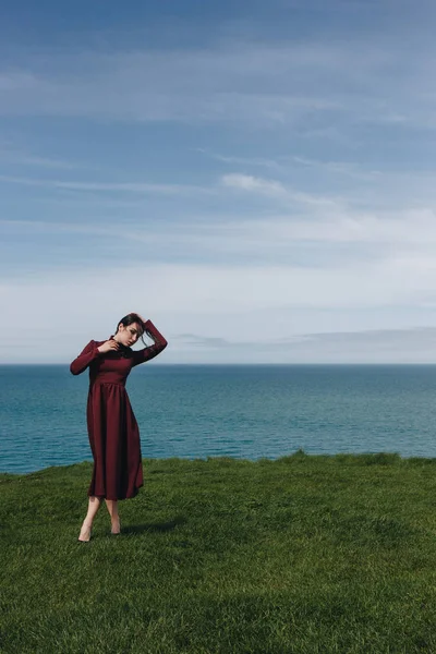 Jovem atraente elegante posando em penhasco perto do mar, Etretat, Normandia, França — Fotografia de Stock