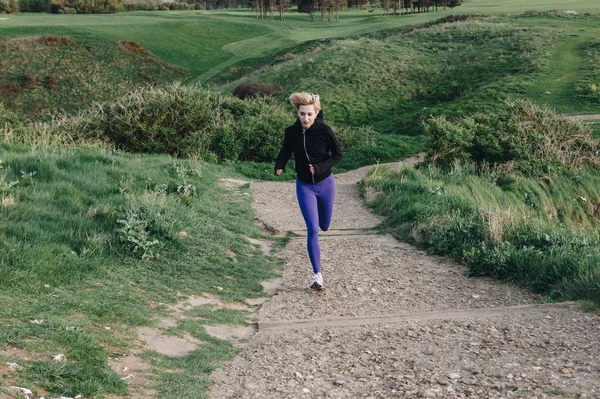 Young sporty woman running on path outdoors, Etretat, France — Stock Photo