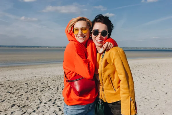 Happy female friends hugging on sandy beach, Saint michaels mount, Normandia, França — Fotografia de Stock