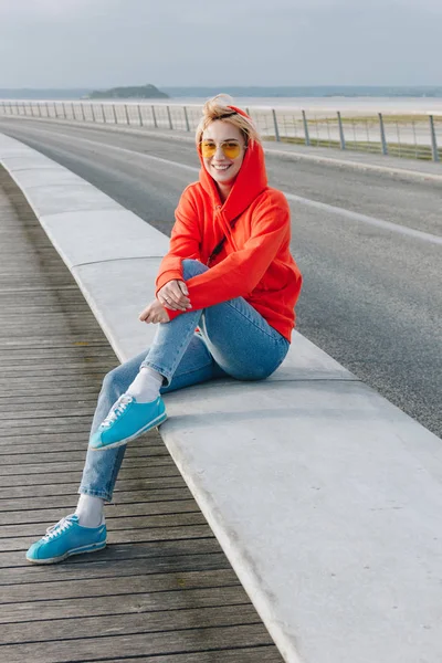 Beautiful happy girl in sunglasses sitting and smiling at camera, mont saint michel, france — Stock Photo