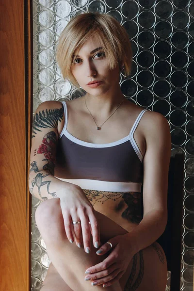 Beautiful sexy tattooed girl in underwear looking at camera — Stock Photo