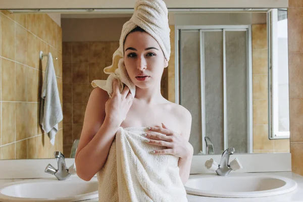 Hermosa chica en toallas mirando a la cámara en el baño - foto de stock