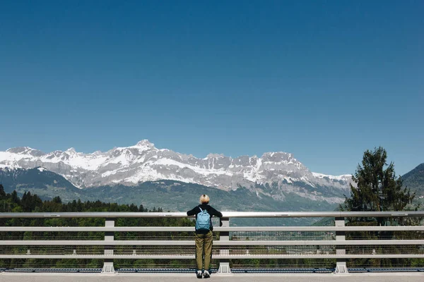Вид сзади девушки с рюкзаком, смотрящей на величественные заснеженные горы, Монблан, Альпы — стоковое фото
