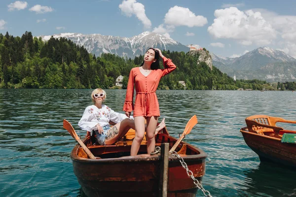 Hermosas mujeres jóvenes en barco en el tranquilo lago de montaña, sangró, slovenia - foto de stock