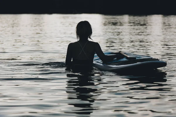 Silhouette of woman in water with paddle board — Stock Photo