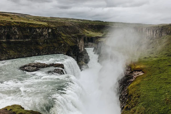 Vista panorámica del vapor sobre la hermosa cascada Gullfoss que fluye a través de las tierras altas en Islandia - foto de stock