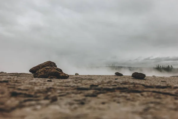 Nível de superfície da paisagem com pedras e vapor sob céu nublado no vale de Haukadalur, na Islândia — Fotografia de Stock