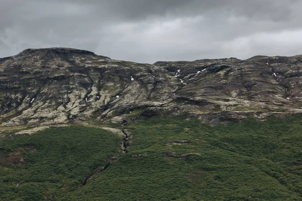 Landschaft mit schneebedeckten Bergen unter bewölktem Himmel in Island — Stockfoto