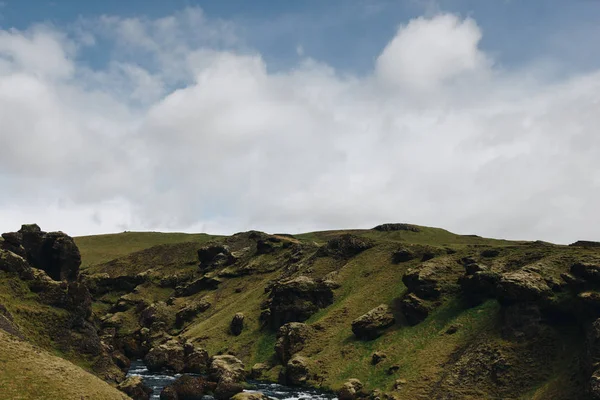 Wolkenverhangener blauer Himmel und wunderschöner Gebirgsfluss, der durch das Hochland in Island fließt — Stockfoto