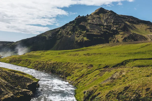 Paisaje con hermoso río Skoga y montaña bajo cielo azul en Islandia - foto de stock