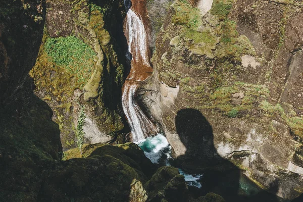 Luftaufnahme des Flusses, der von einem Berg mit Sonnenlicht in die Schlucht des Fjadrargljufur in Island fließt — Stockfoto