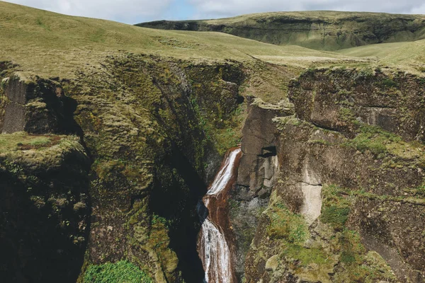 Vista panorámica del río que desciende de la montaña con la luz del sol en el cañón de Fjadrargljufur en Islandia - foto de stock