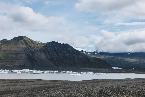 Belles montagnes et lac sous un ciel nuageux dans le parc national Skaftafell en Islande — Photo de stock