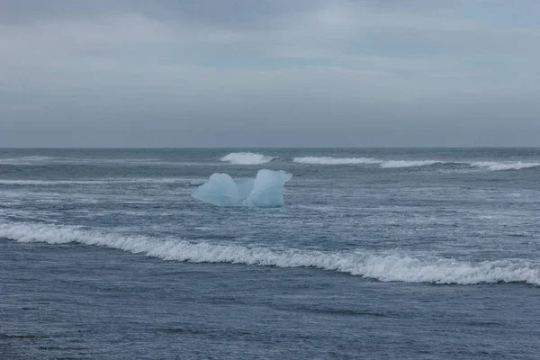 Trozo de hielo glaciar azul flotando en el agua del océano, Islandia - foto de stock
