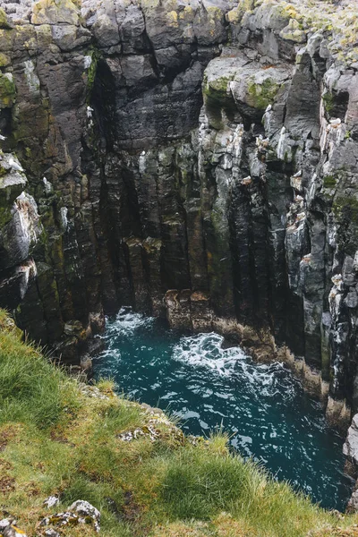 Пташиного польоту кам'янистій скелі і гуркіт синіх хвиль в Ісландії — стокове фото