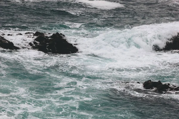 Драматический выстрел океанских волн, падающих на скалы — стоковое фото