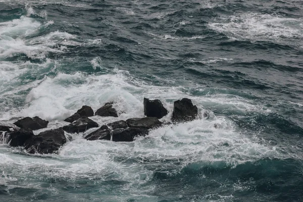 Coup dramatique des vagues de l'océan s'écrasant sur les rochers pour fond — Photo de stock