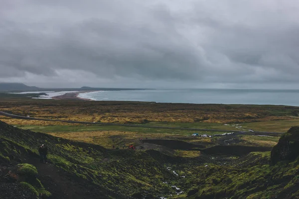 ISLANDIA - 22 DE JUNIO DE 2018: pintoresco con de costa icelándica y valle verde con multitud de turistas - foto de stock