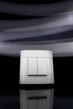 Robot, koyu siyah duvara yüklü beyaz renkteki plastik bir mekanik düğme.