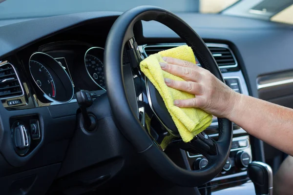 Trabajador con cepillo limpia la rejilla del conducto de aire del coche,  limpieza en seco y detallado.