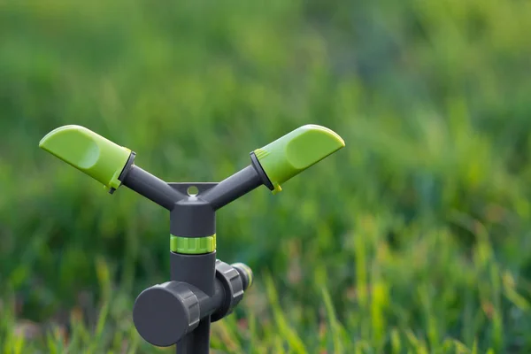Aspersor giratorio de 2 brazos sobre espiga con fondo de hierba verde —  Fotos de Stock