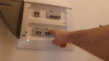 Devre kesici kurulu birçok anahtarları görüntüler. Bir parmak yaklaşık çevirmek o sırt üstünde etmektir.