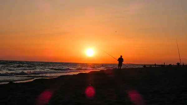 Fisherman Catches Fish Sea Sunset Seashore Royalty Free Stock Images