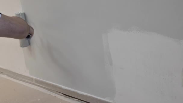 흰색 페인트를 칠 한 페인트 롤러 가집 의벽을 페인트로 그린다 — 비디오